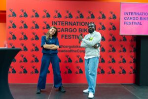 Arieke van Liere en Otasowie Obayuwana op het podium voor het doek van het International Cargo Bike Festival.